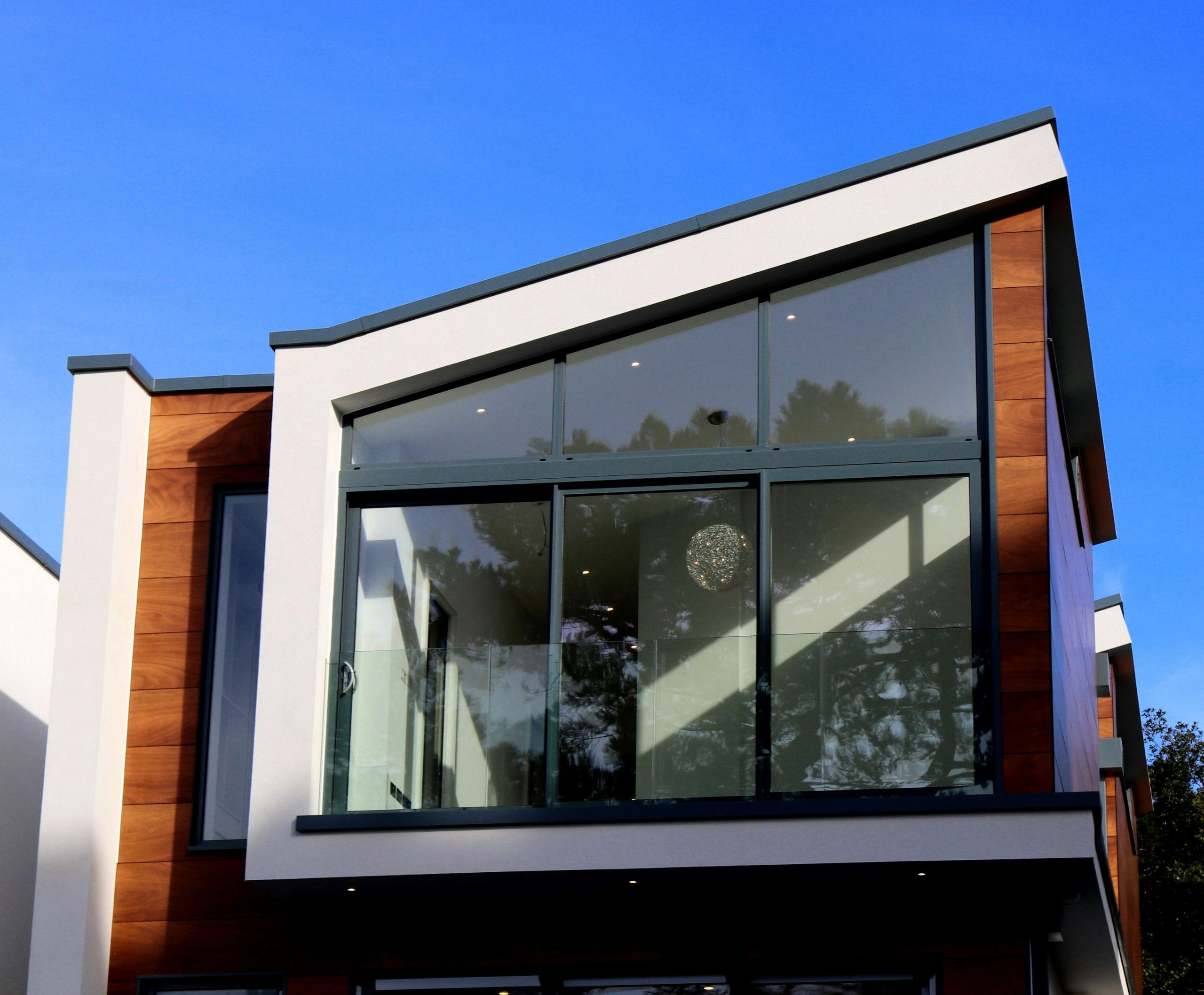 Modern huis met grote ramen en houten afwerking.