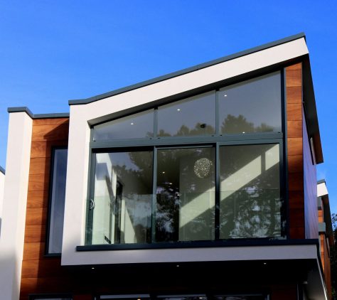Modern huis met grote ramen en houten afwerking.